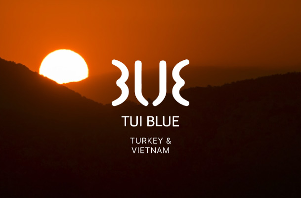 Sunset in front of a panorama of hills and the Tui Blue logo