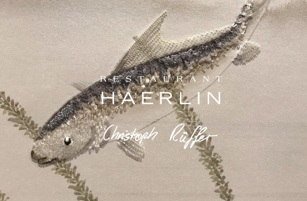 Photo of the three-dimensional wallpaper with sequin fish and the Haerlin restaurant logo***